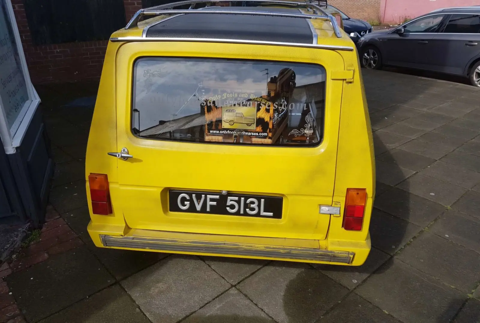 The yellow three-wheeler seen straight on from the rear